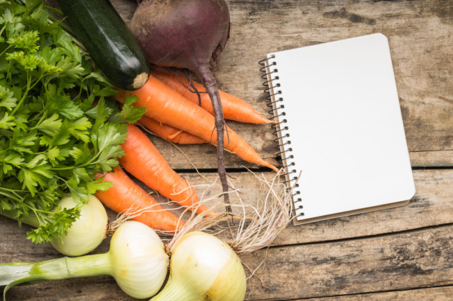 Recipe background. Fresh vegetables with blank page of cookbook